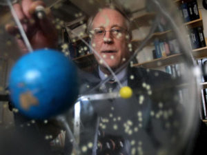 Professor Richard Binzel looking through an orrery