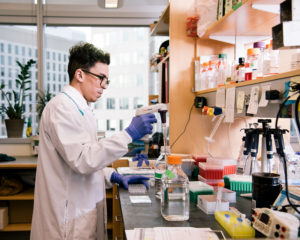 A graduate student uses a pipette in a lab.