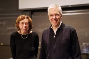 man and woman stand in front of a chalkboard