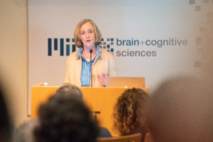 woman at podium in front of Brains on Brains sign