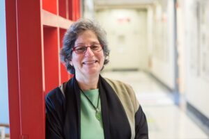 Susan Solomon leans against a corridor wall