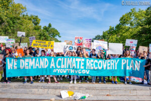 Young activists protest with bright colored banners with climate change slogans