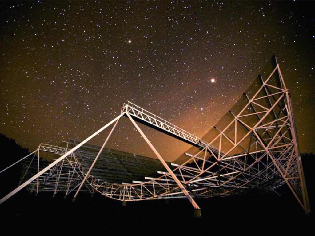 Large radio satellite against a starry night sky