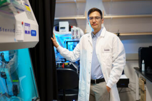 Sebastian Lourido wears a white coat in a lab