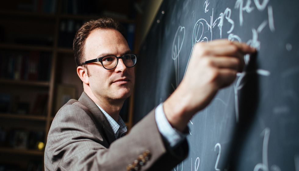 Jesse Thaler writes on a chalkboard