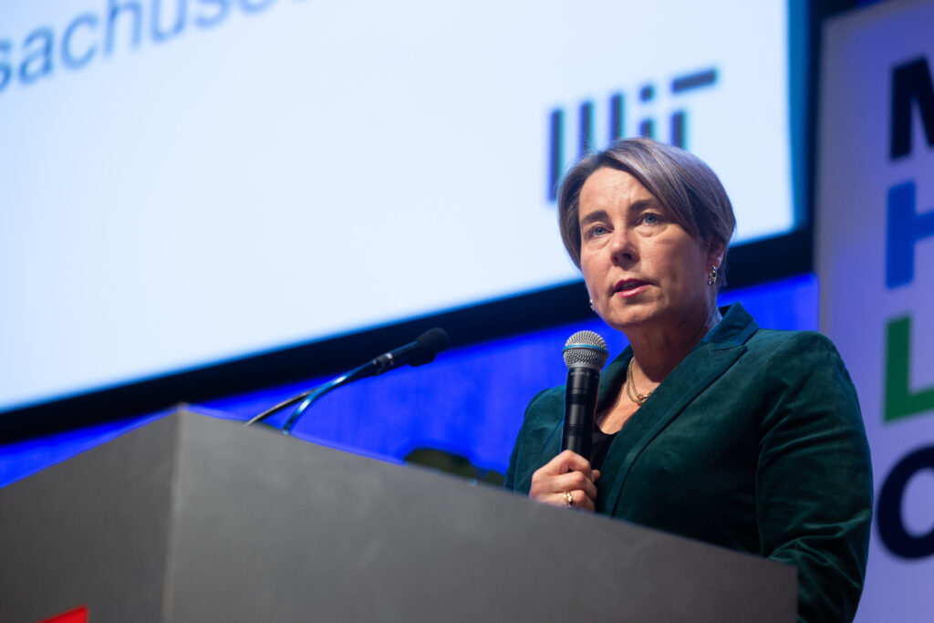 Maura Healey at a podium holding a microphone