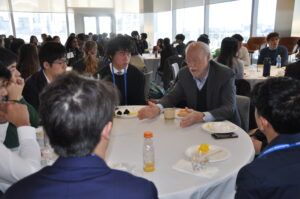 Phillip Sharp talks with table of students at AJAS breakfast