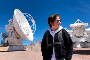 Jess Speedie stands outside with one of the ALMA dishes behind her.
