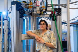 Faith Reyes stands in front of a large device in the lab. Photo: Jodi Hilton
